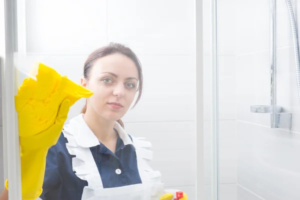 Atractiva ama de llaves o criada limpiando una ducha — Foto de Stock