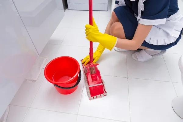 Empregado que ajusta um pano limpo a uma esfregona — Fotografia de Stock