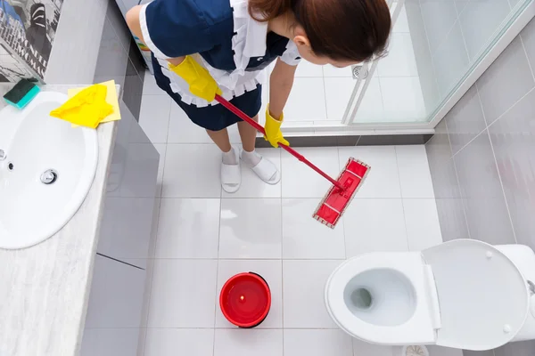 Empregada doméstica ou empregada doméstica limpando o chão — Fotografia de Stock
