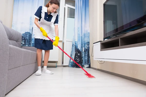 Mucama o ama de llaves limpiando una sala de estar — Foto de Stock