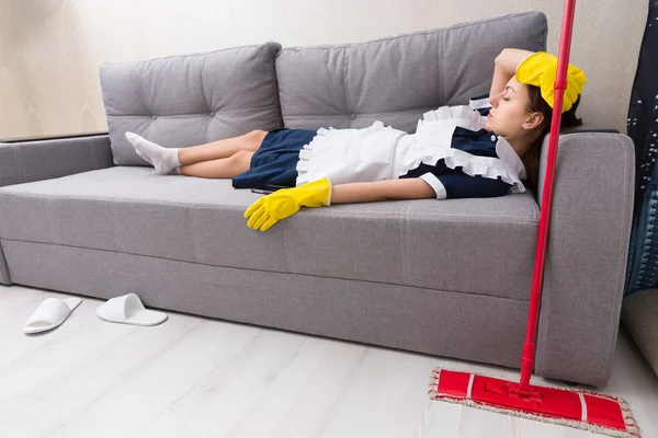 Exhausted housekeeper relaxing on the job — Stock Photo, Image