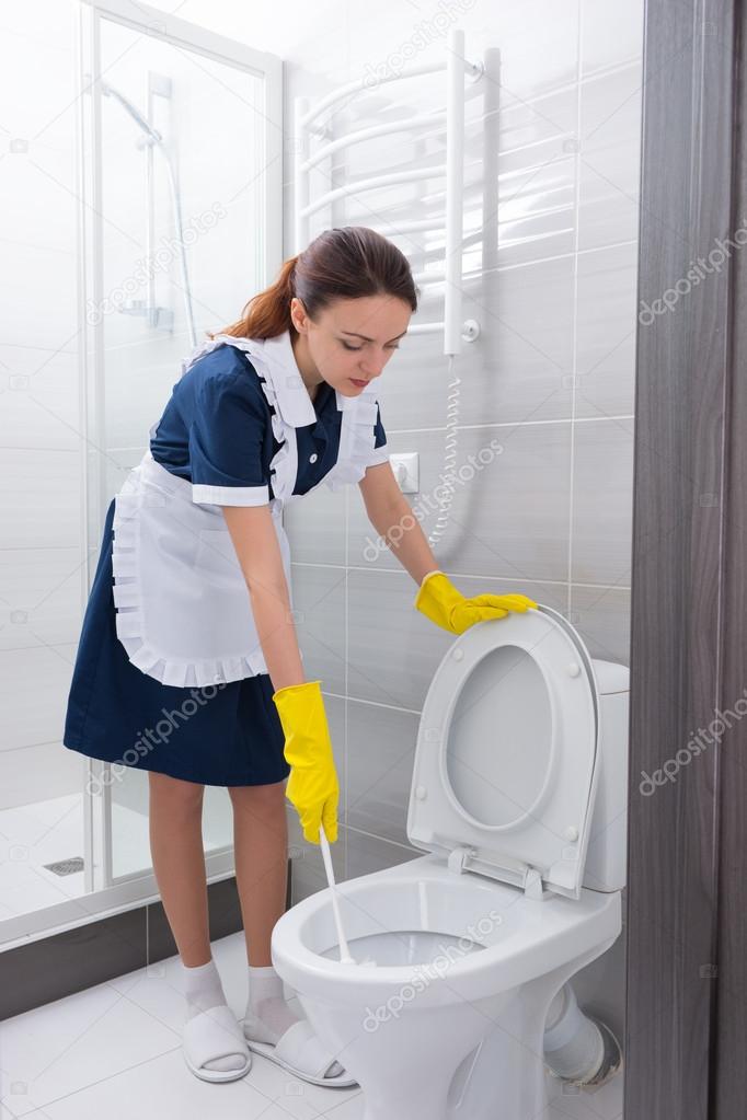 Attractive housekeeping cleaning out a toilet ⬇ Stock Photo, Image by
