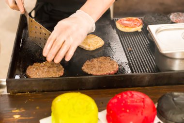 Sığır köftesi bir kalbur üzerinde ızgara kişi