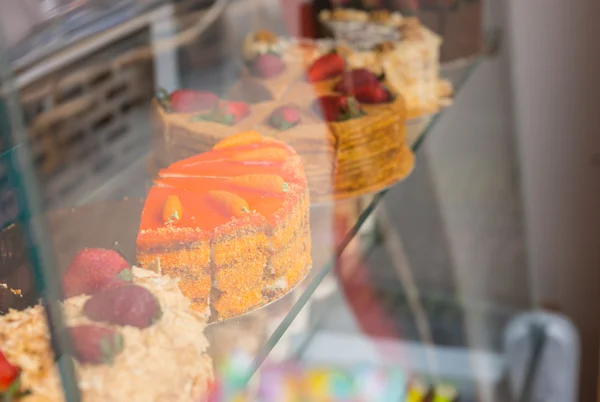 ベーカリーの窓にグルメケーキの選択 — ストック写真