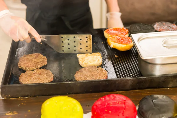 Человек, который делает гамбургеры на сковородке — стоковое фото