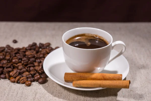 Taza llena de café con canela sobre mantel — Foto de Stock