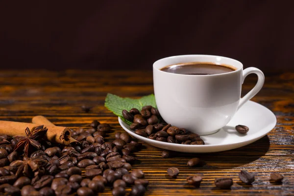 Single full coffee with beans on table — Stock Photo, Image