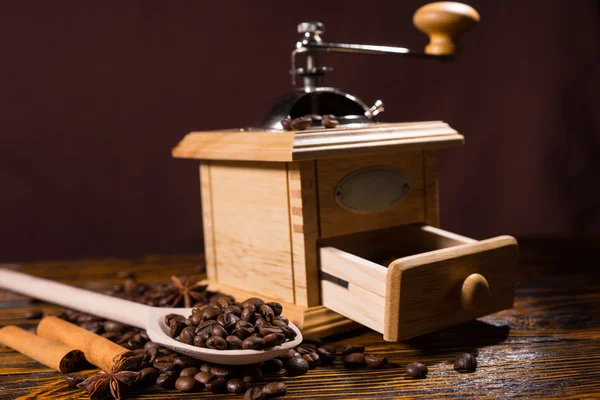 Moedor de mão e colher de madeira com grãos de café — Fotografia de Stock