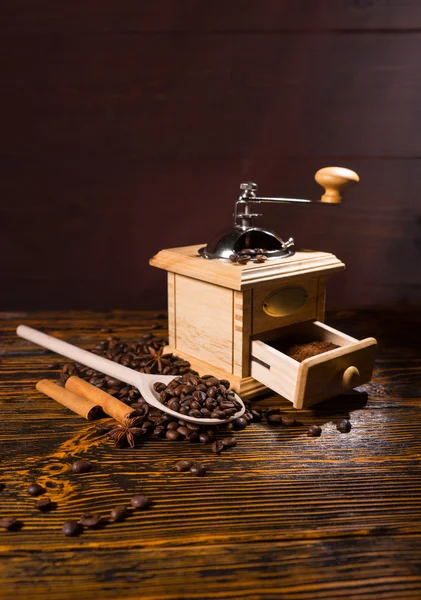 Moedor de mão e colher de madeira com grãos de café — Fotografia de Stock