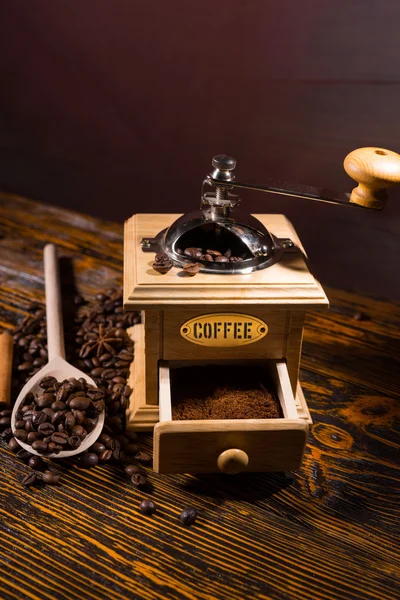 Kavrulmuş kahve çekirdekleri, tahta kaşık ve El değirmeni
