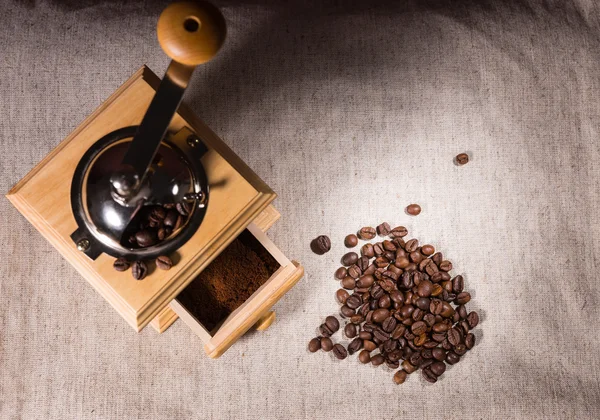 Molinillo de café, molido y frijoles sobre tela —  Fotos de Stock