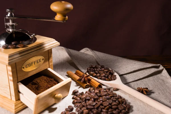 Colher de madeira segurando grãos de café por moedor — Fotografia de Stock