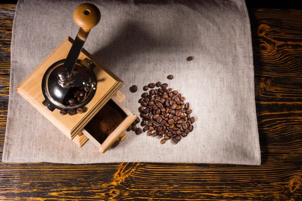 Moedor de café, moído e grãos na toalha de mesa — Fotografia de Stock