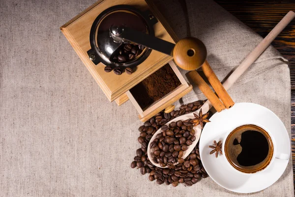 Moedor com grãos de café e colher de madeira — Fotografia de Stock