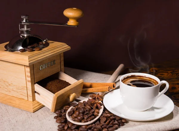 Café caliente fresco en taza blanca al lado de molinillo —  Fotos de Stock