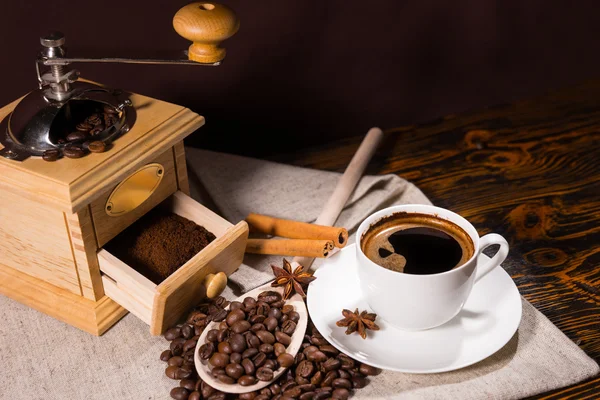 Grinder with freshly ground coffee beside beans — Stockfoto