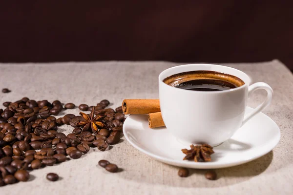 Frijoles de café sueltos junto a taza y anís estrellado — Foto de Stock