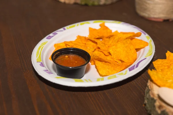 Опытные чипсы Тортилья с сальсой на бумажной тарелке — стоковое фото