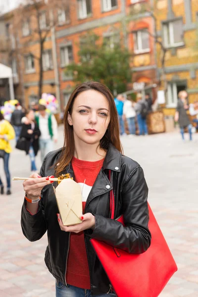 アジアを食べる若い女性は忙しいお祭りでアウトを取る — ストック写真
