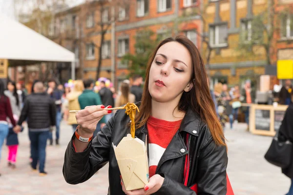Jovem mulher comer asiático tirar no ocupado Festival — Fotografia de Stock