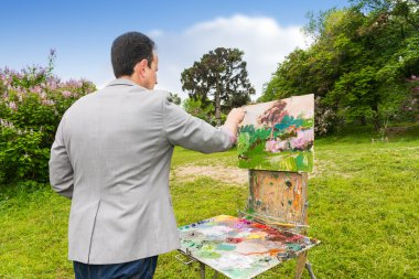 Orta yaşlı moda erkek ressam bir eskiz defteri üzerinde çalışma 