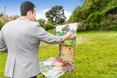 Arkadan görünüşü onun resmi bitirdikten bir erkek sanatçı 