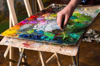 Erkek ressamın el paletteknife ile çalışma