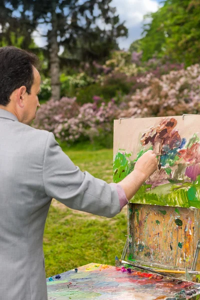 Mužského umělce dotváří obraz v parku — Stock fotografie