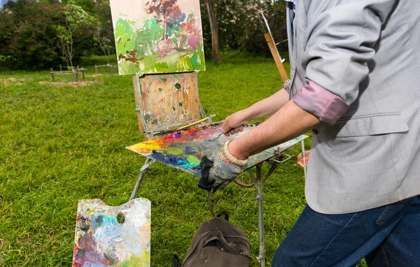 Мужской созерцательный художник очищает свою палитру — стоковое фото