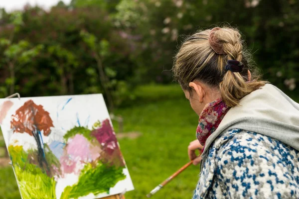 Γυναίκα καλλιτέχνης απερίσπαστη paintig τελευταίες πινελιές σε ένα πάρκο — Φωτογραφία Αρχείου