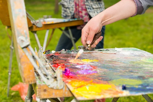 Manlig hand blanda ljusa färger med en paletteknife — Stockfoto