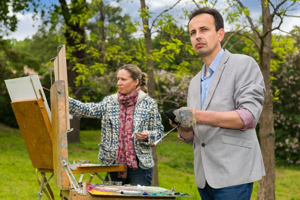 Twee middelbare leeftijd dromerige schilders tijdens een kunst-klasse in een park — Stockfoto