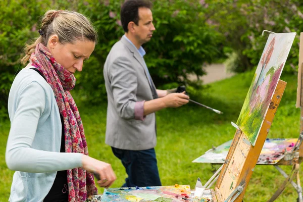 Pareja de artistas concentrados en un proceso en un parque — Foto de Stock