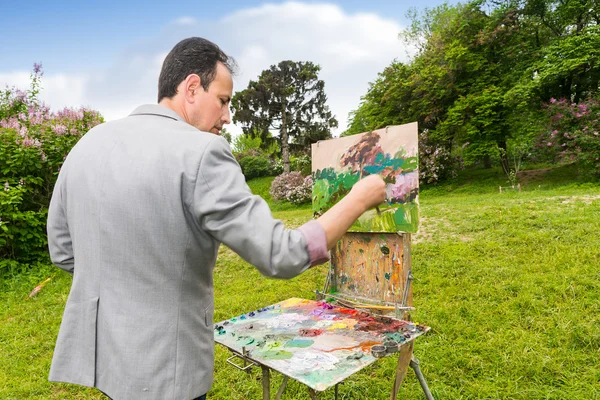 Middle-aged fashionable male professional artist finishing his w — Stock Photo, Image