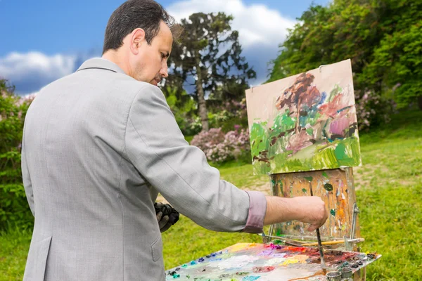 Zijaanzicht van een een geconcentreerde mannelijke artiest tijdens een kunst-klasse — Stockfoto