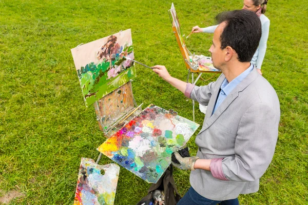 Couple of middle-aged fashionable professional artists in a park — Stock Photo, Image