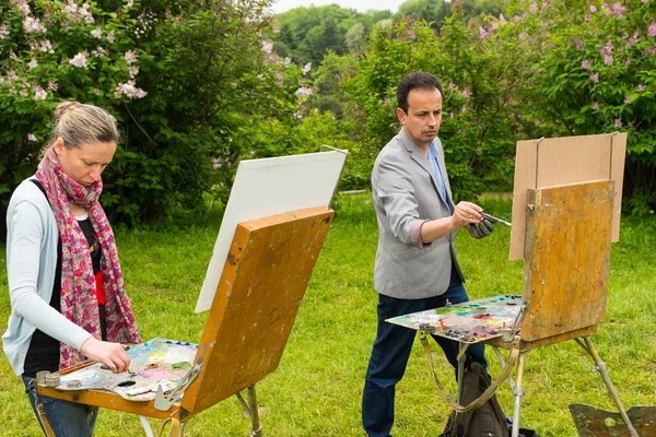 Two professional creative pensive painters painting in a garden — Stock Photo, Image