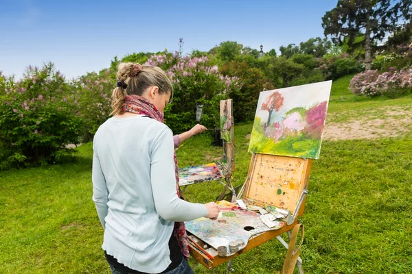 Bakifrån av en koncentrerad kvinnliga målare under en konst klass — Stockfoto