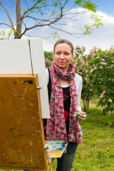 Iloinen naisartisti työskentelee puistossa — kuvapankkivalokuva