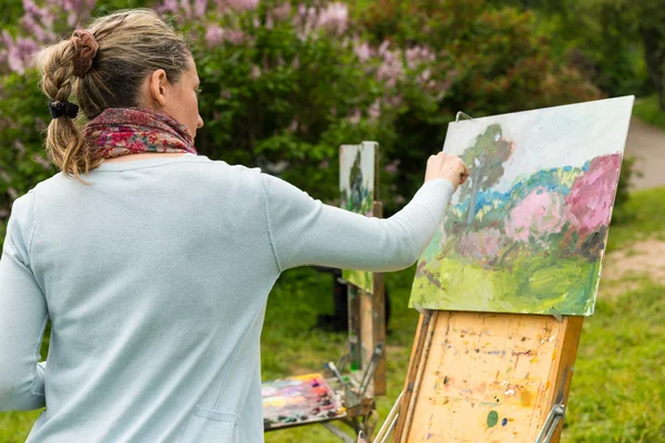 Жінка живописець панчохами її шедевр в саду — стокове фото