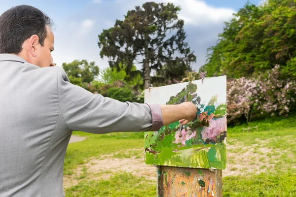 Vue arrière d'un homme peintre travaillant à l'extérieur dans le parc ou la garde — Photo