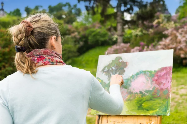 Bakifrån av en kvinnlig artist som arbetar utomhus i parken eller gar — Stockfoto