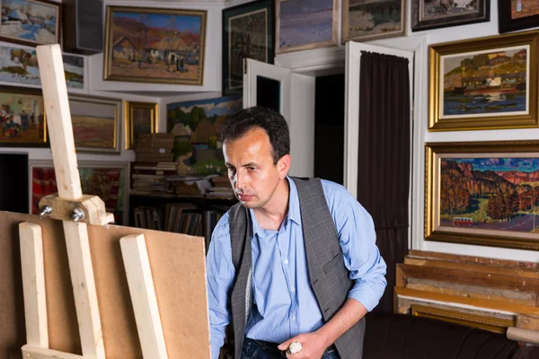 Artista masculino contemplativo centrado en la pintura de su cuadro — Foto de Stock