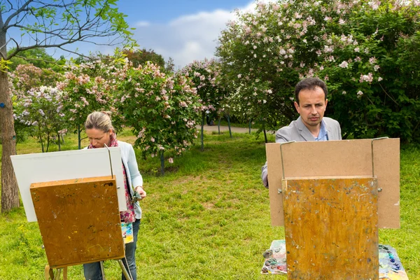 Serious man and woman painters painting in the open air — Stock Photo, Image