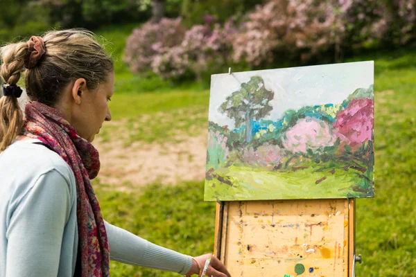 Vrouwelijke schilder buitenshuis werken in het park — Stockfoto