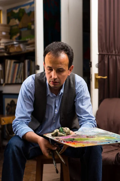 Pintor masculino segurando uma paleta de artistas coloridos — Fotografia de Stock
