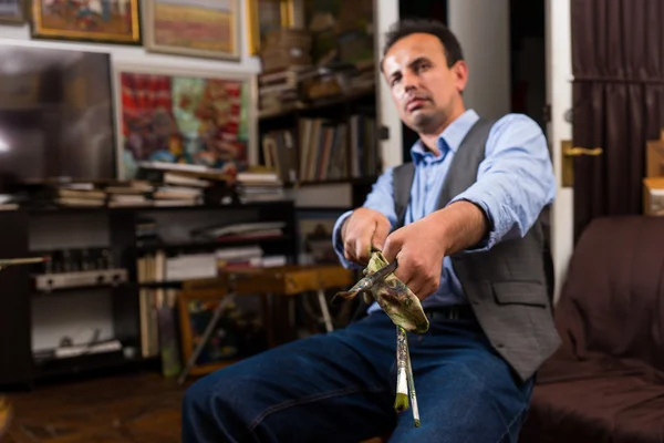 Artist cleaning off his paintbrush with a rag — Stock Photo, Image