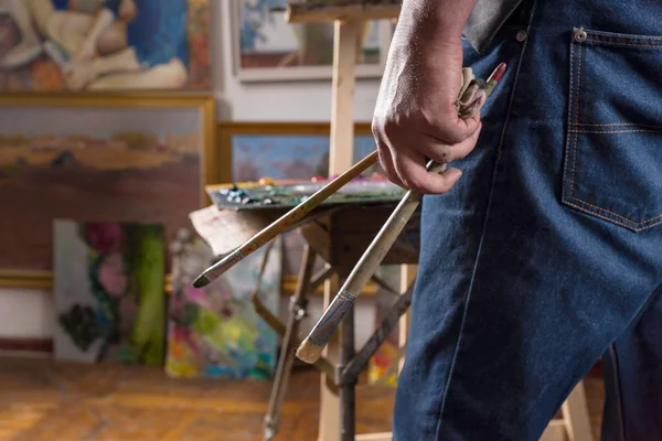 Hand of an artist with a paint brush — Stock Photo, Image