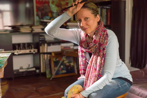 Женщина-художник делает паузу, чтобы вытереть лоб — стоковое фото