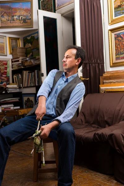 Male handsome artist holding paintbrushes — Stock Photo, Image